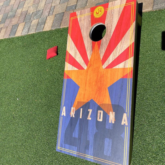 Arizona state flag themed cornhole board with a large copper star