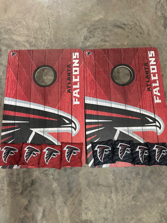 NFL Atlanta Falcons cornhole set on a red wood grain background