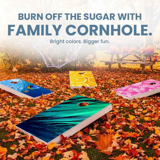 Four brightly colored custom cornhole boards laid on autumn leaves