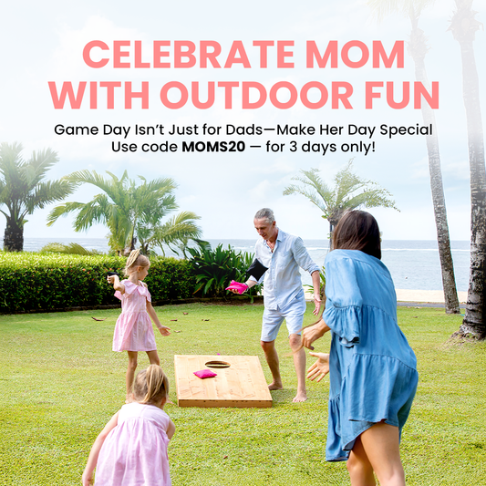 Family playing yard cornhole on a lawn near the beach with pink bean bags