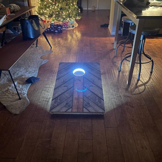 cornhole board with an illuminated blue LED hole ring