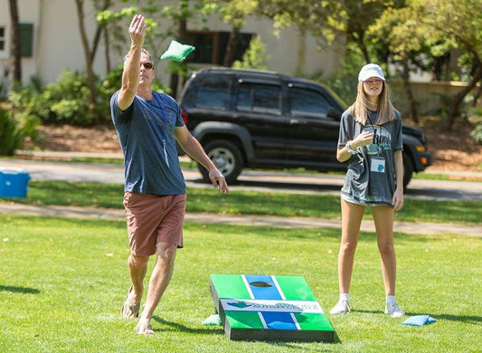 two people playing cornhole competitively