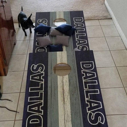 cornhole boards with blue and grey bean bags, featuring a small black dog