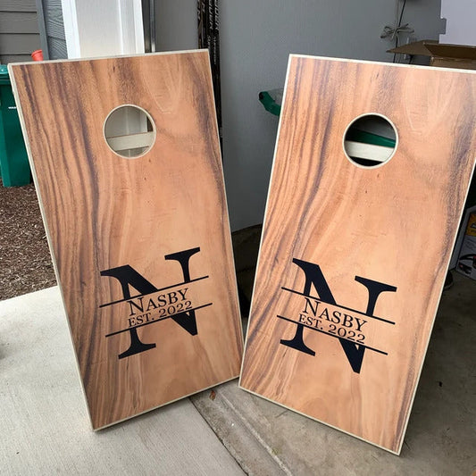 Wood look cornhole boards with black monogram and text.