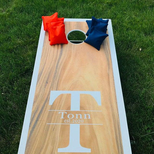 Personalized cornhole board with bags on grass