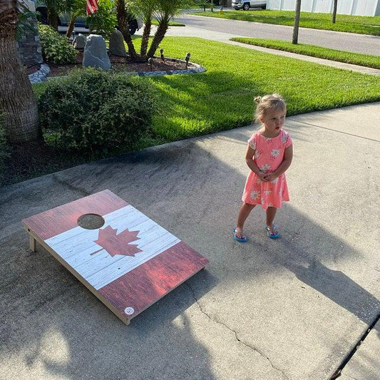 girl playing cornhole with her mom