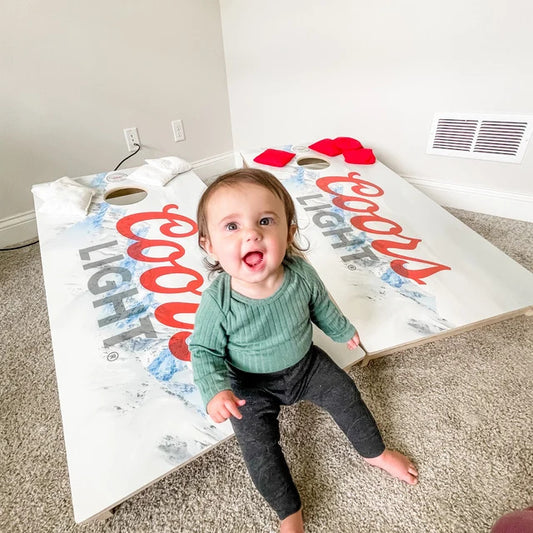 baby with cornhole boards
