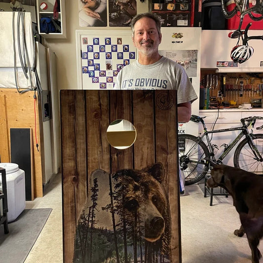 dad and kid holding bear themed cornhole boards