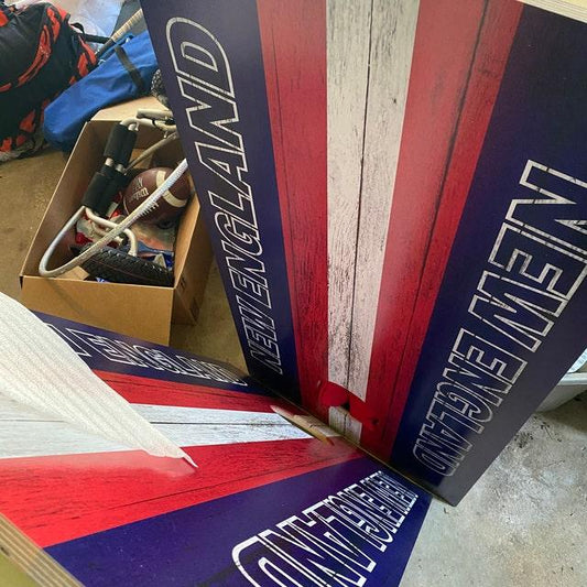 Custom "New England" themed cornhole boards with red, white, and blue stripes.